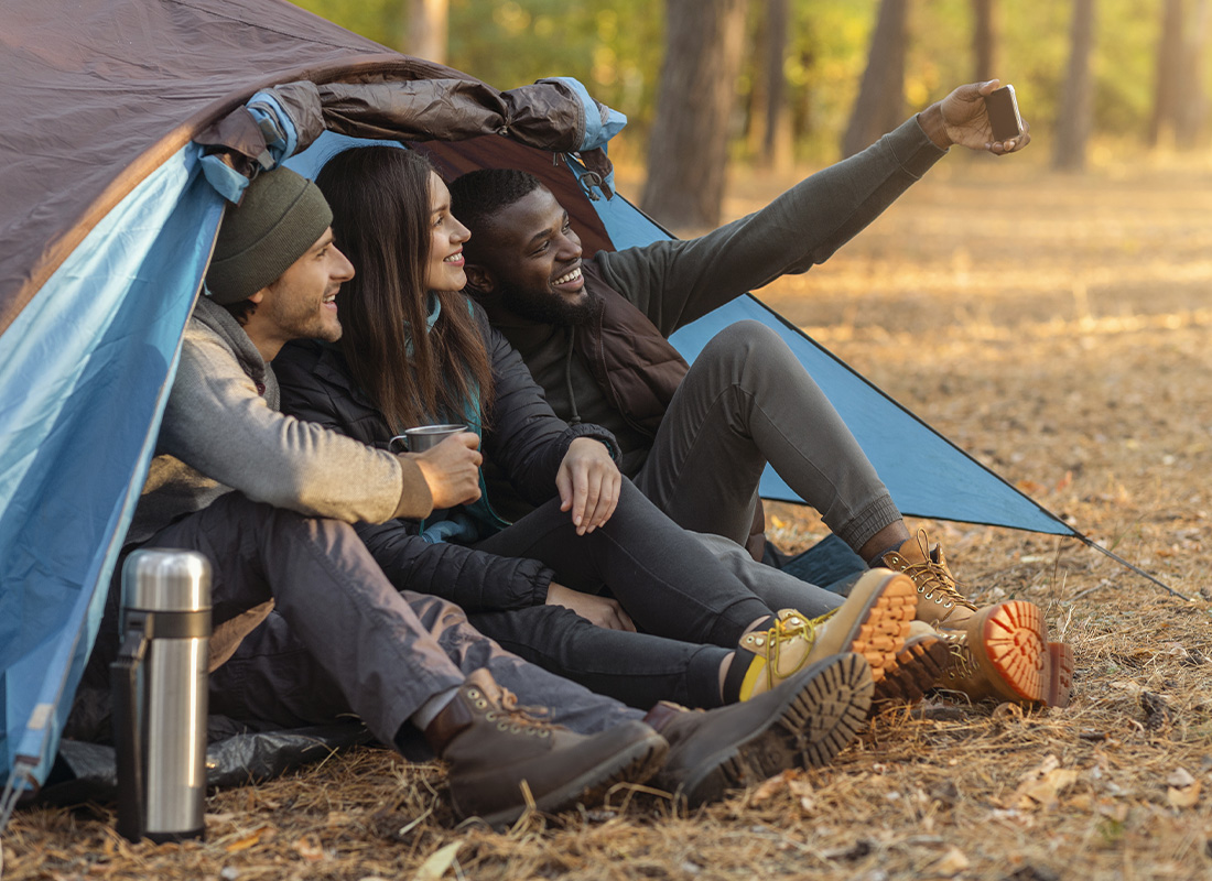 Campsite Insurance - Friends Camping Together in the Woods and Taking Selfie on Phone in the Fall