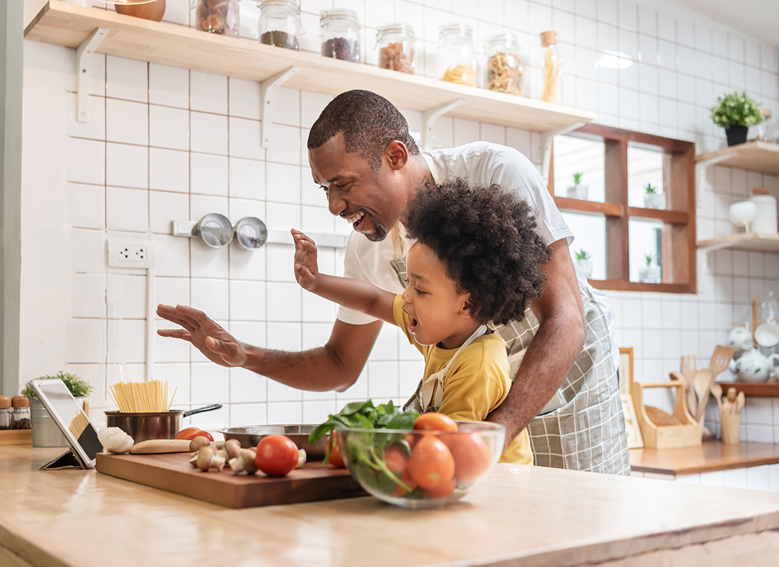 About Our Agency - Cheerful Dad and Child Prepare Dinner Together